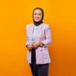 seorang wanita dengan jaket ungu dan syal hitam